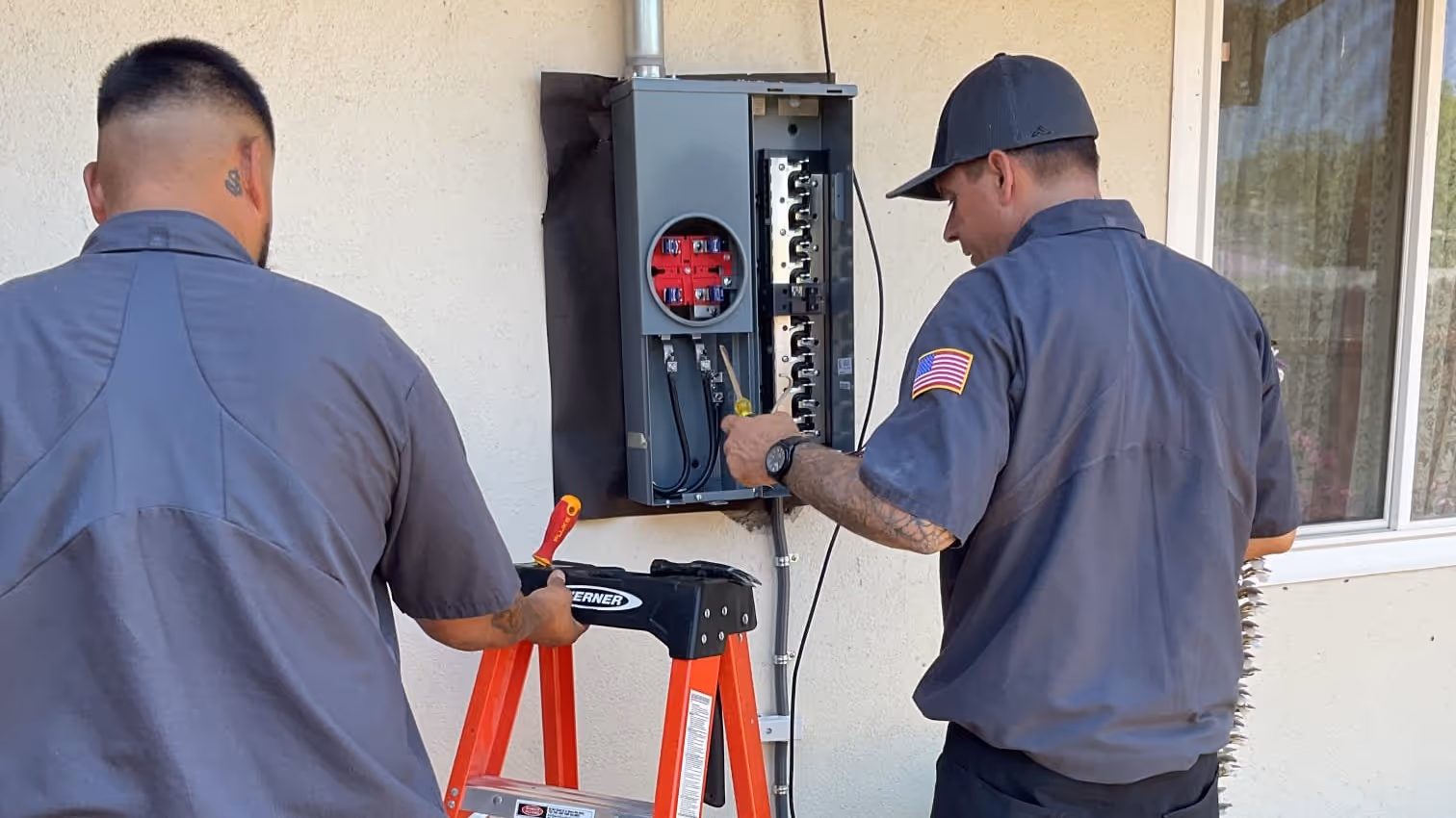 AAA technicians working together at a residential electrical panel